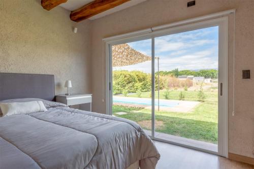 a bedroom with a bed and a large sliding glass door at Casa en chacras de coria in Mendoza