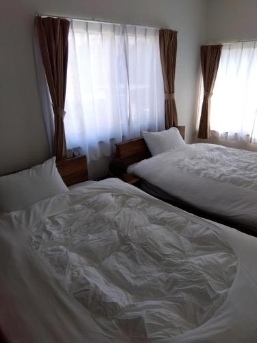 a bedroom with two beds and a window at Tsunageru Aomori Yasukata - Vacation STAY 40732v in Aomori