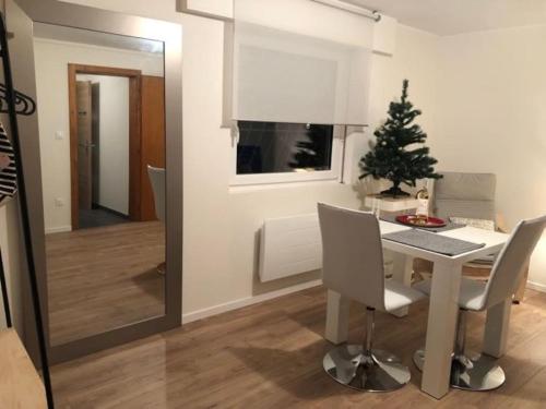un comedor con una mesa y un árbol de Navidad en Joli appartement individuel dans maison en Ostwald