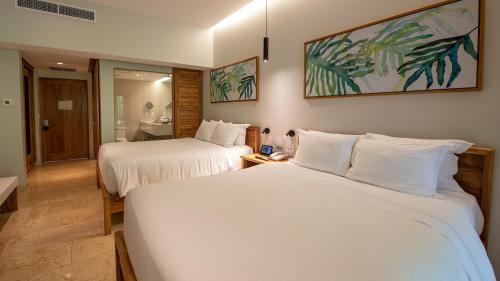 a hotel room with two beds and a bathroom at Tabacón Thermal Resort & Spa in Fortuna