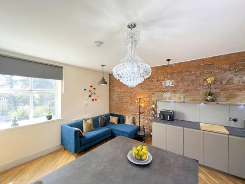 uma sala de estar com um sofá azul e uma cozinha em The Yorkshire Hosts - Knights Stay 