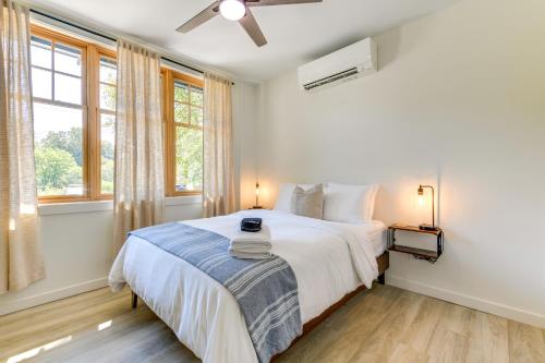 una camera da letto bianca con un letto grande e finestre di Walk to Downtown Brevard Apt with Patio and Fire Pit! a Brevard