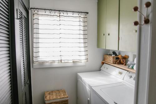 a laundry room with a washer and dryer and a window at Bay Point Hideaway in the Woods in Beulah