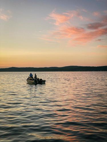 two people in a boat on a large body of water at Bay Point Hideaway in the Woods in Beulah