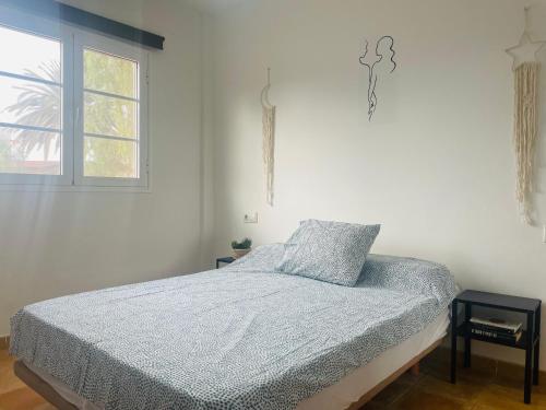 a bedroom with a bed with a blue comforter and a window at VillaMar in Villaverde