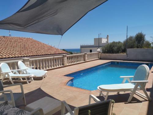 a swimming pool with lounge chairs and a table at CAN TRULLEN CHALET CALAFELL in Calafell