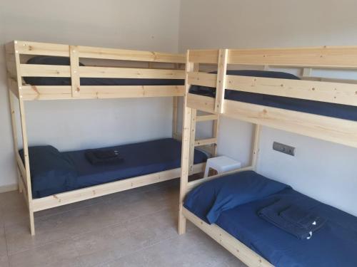 a room with three bunk beds with blue sheets at CAN TRULLEN CHALET CALAFELL in Calafell