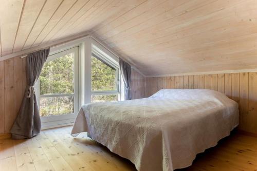 a bedroom with a bed and a large window at Cozy cabin w/garden, BBQ, canoe, swimming, central in Sinnes