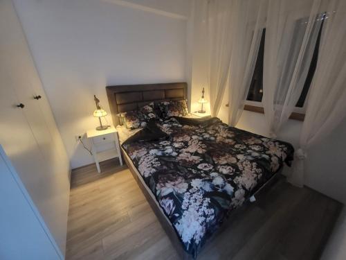 a bedroom with a bed and a window and two lamps at Azur in Jagodina