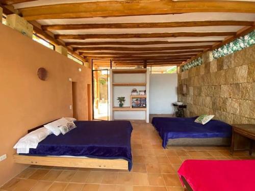 a bedroom with two beds and a stone wall at Casa descanso familiar Silvania in Silvania