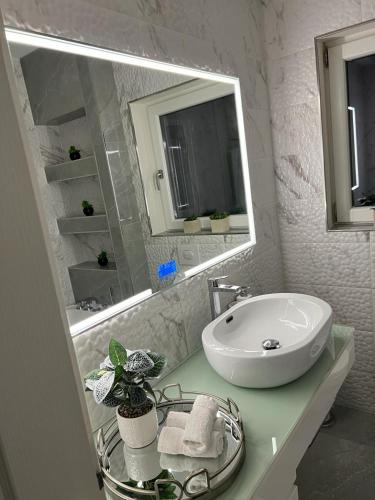 a white bathroom with a sink and a mirror at Neagoe residents in Birkirkara