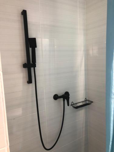 a shower with a black shower head in a bathroom at Будинки рибалки in Sudovaya Vishnya
