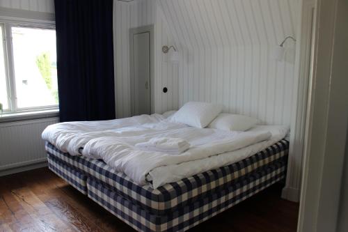 ein großes Bett in einem Zimmer mit Fenster in der Unterkunft Lovisas Stuga in Vadstena