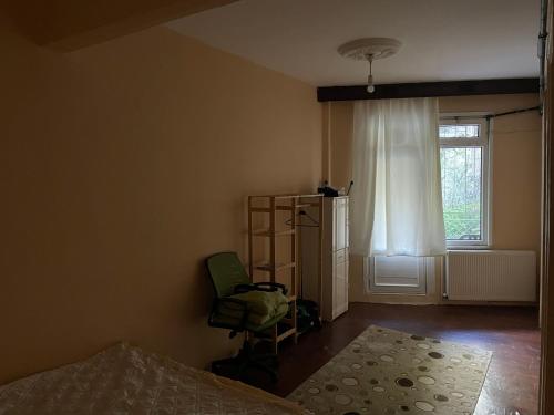 um quarto com uma cama, uma cadeira e uma janela em Yeldeğirmeni Marmaray dibi em Istambul