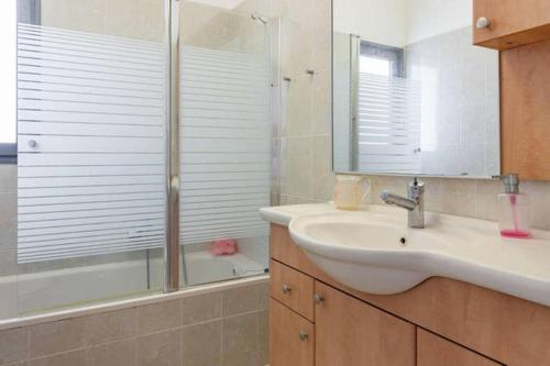 y baño con lavabo y ducha. en Netanya Family Apartment with Balcony by FeelHome, en Netanya