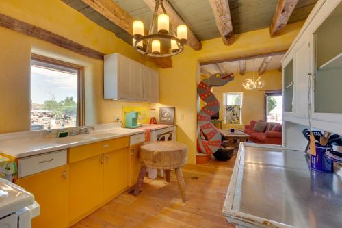 cocina con paredes amarillas, fregadero y taburete en Santa Cruz Home with Mountain Views!, en Santa Cruz