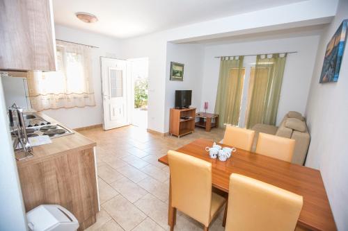 a kitchen and dining room with a wooden table and chairs at Ferienhaus Elena, Karlobag in Karlobag