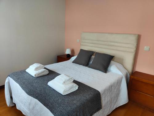 una camera da letto con un letto con due asciugamani sopra di Casinha da Vila a Arouca