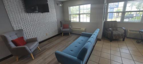 a waiting room with a blue couch and chairs at Microtel Inn & Suites by Wyndham Hoover/Birmingham in Hoover