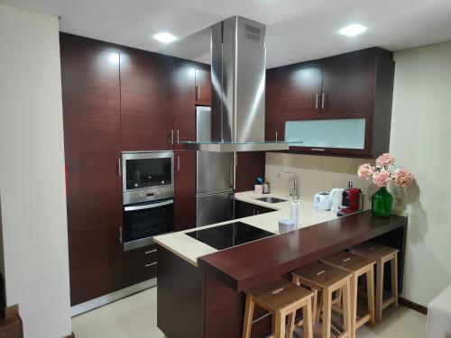 a kitchen with wooden cabinets and a counter top at Casinha da Vila in Arouca