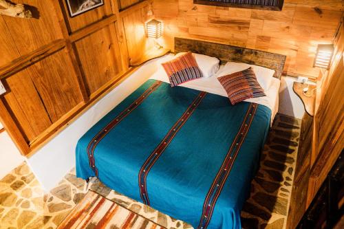 Mountain Nest في لانكوين: سرير كبير في غرفة بجدران خشبية