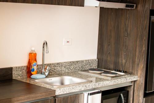 a kitchen counter with a sink and a stove at Loft nuevo con gran vista in Bogotá