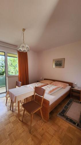 1 dormitorio con 1 cama, mesa y sillas en Haus Carinthia Wörthersee Kärnten, en Krumpendorf am Wörthersee