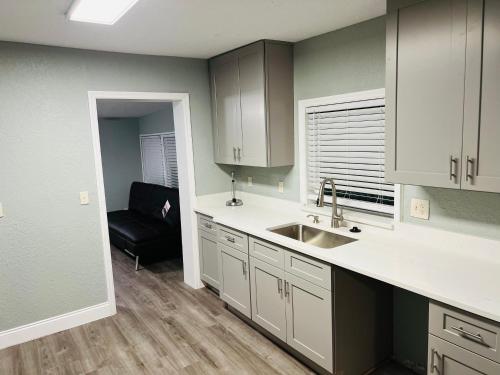 eine Küche mit einem Waschbecken und einem Sofa in einem Zimmer in der Unterkunft 3bdrm Fruit Tree Home near downtown Orlando in Orlando