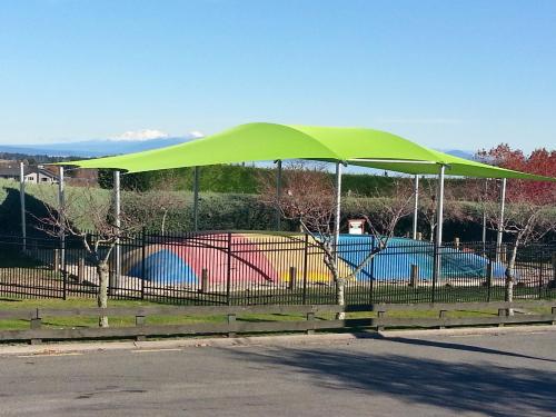 a green canopy over a fence on a street at Taupo Debretts Spa Resort in Taupo