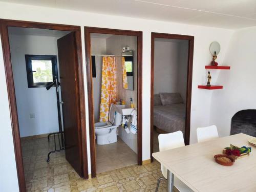 a room with a bathroom with a toilet and a table at Pequeña casa rural en el centro del Delta del Ebro in Amposta