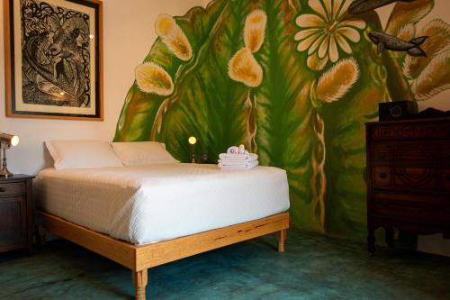 1 dormitorio con 1 cama y una pintura en la pared en Casa Bahia en La Paz