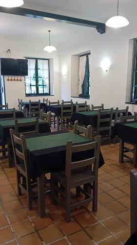 una habitación con mesas verdes y sillas. en Pension ILARRAZABAL, en Azpeitia