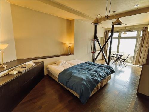 1 dormitorio con 1 cama y 1 mesa en una habitación en Umi no Gohanya Noramare - Vacation STAY 18185v en Masuda