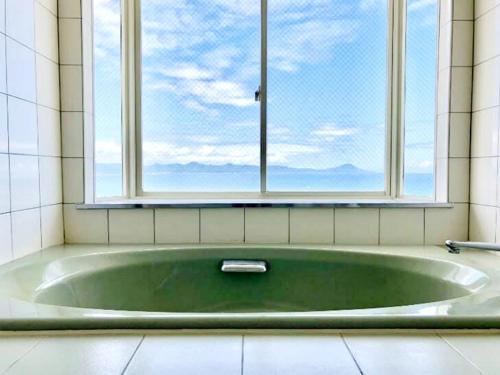 uma banheira na casa de banho com uma janela em Umi no Gohanya Noramare - Vacation STAY 18140v em Masuda
