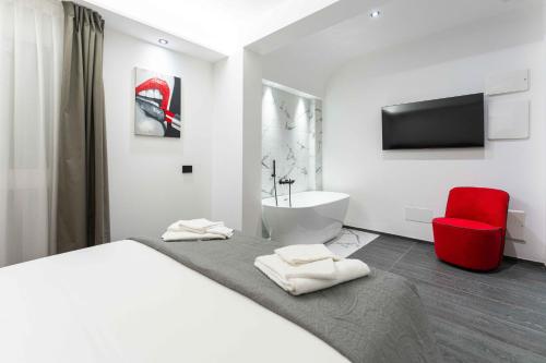 - une chambre avec un lit et une chaise rouge dans l'établissement ML luxury room, à Lido di Spina