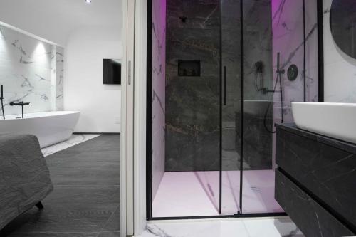 a bathroom with a shower and a sink and a tub at ML luxury room in Lido di Spina