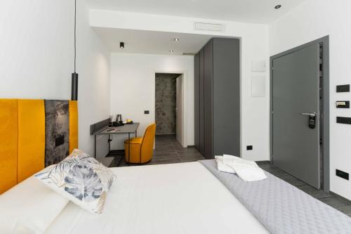 a bedroom with a large white bed and a desk at ML luxury room in Lido di Spina