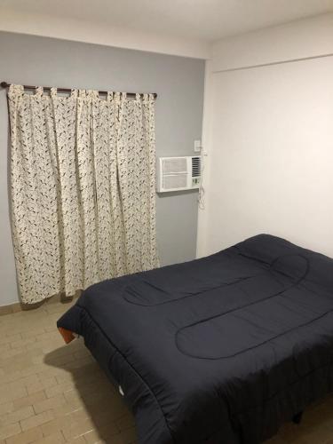 a bedroom with a bed and a window with curtains at Departamento 4 dormitorio in Corrientes