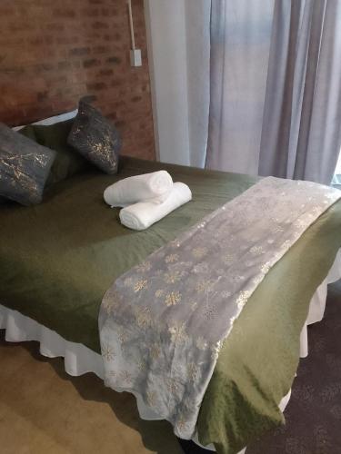 uma cama com duas toalhas em cima em The Eden lodge em Joanesburgo