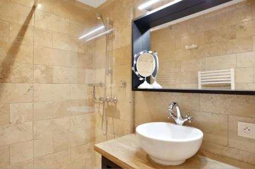 La salle de bains est pourvue d'un lavabo et d'une douche. dans l'établissement Face aux Thermes: lit double, terrasse, wifi, à Saint-Martin-dʼUriage