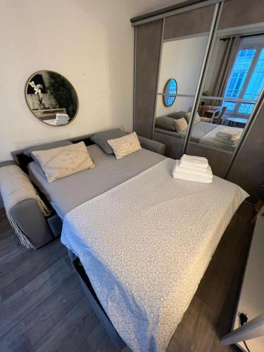 deux lits jumeaux dans une chambre avec un miroir dans l'établissement Studio moderne au cœur de Paris Batignolles, à Paris