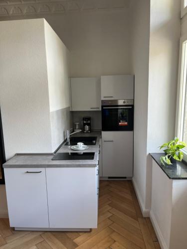 a white kitchen with a sink and a stove at Moseltürmchen Cochem in Cochem