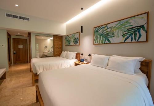 a hotel room with two beds and a bathroom at Tabacón Thermal Resort & Spa in Fortuna