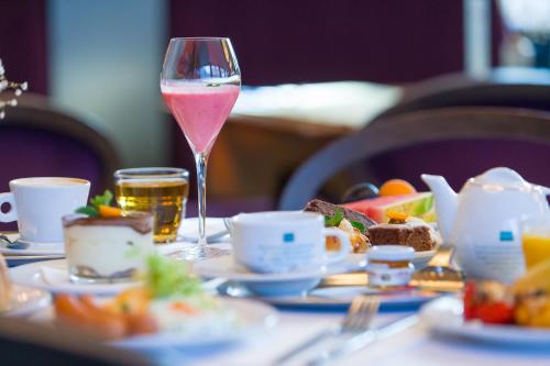 un bicchiere di vino seduto su un tavolo con cibo di Hotel Aplaus a Litomyšl