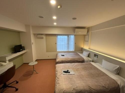 a hotel room with two beds and a television at Hotel Alpha Inn Akita - Vacation STAY 67275v in Akita