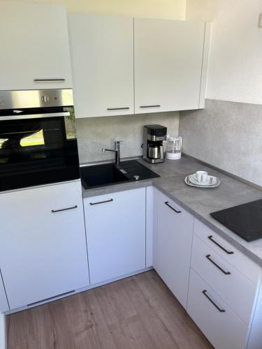 a kitchen with white cabinets and a sink at Moseltürmchen Cochem in Cochem