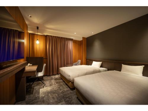 a hotel room with two beds and a desk at Misawa City Hotel - Vacation STAY 81776v in Misawa