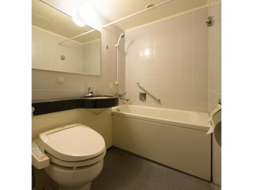 La salle de bains est pourvue de toilettes et d'une baignoire. dans l'établissement Misawa City Hotel - Vacation STAY 81776v, à Misawa