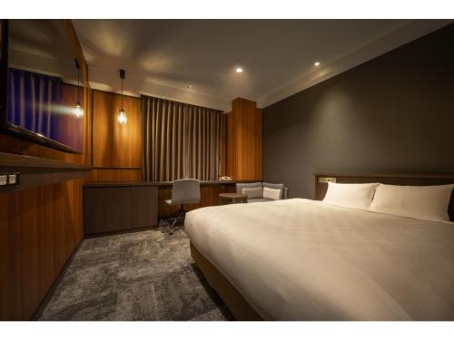 una camera d'albergo con letto e scrivania di Misawa City Hotel - Vacation STAY 81764v a Misawa