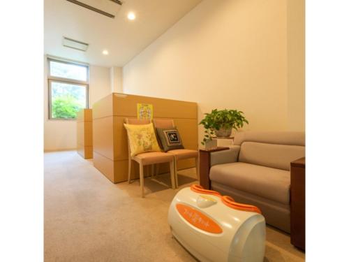 a living room with a couch and a chair at Misawa City Hotel - Vacation STAY 81780v in Misawa